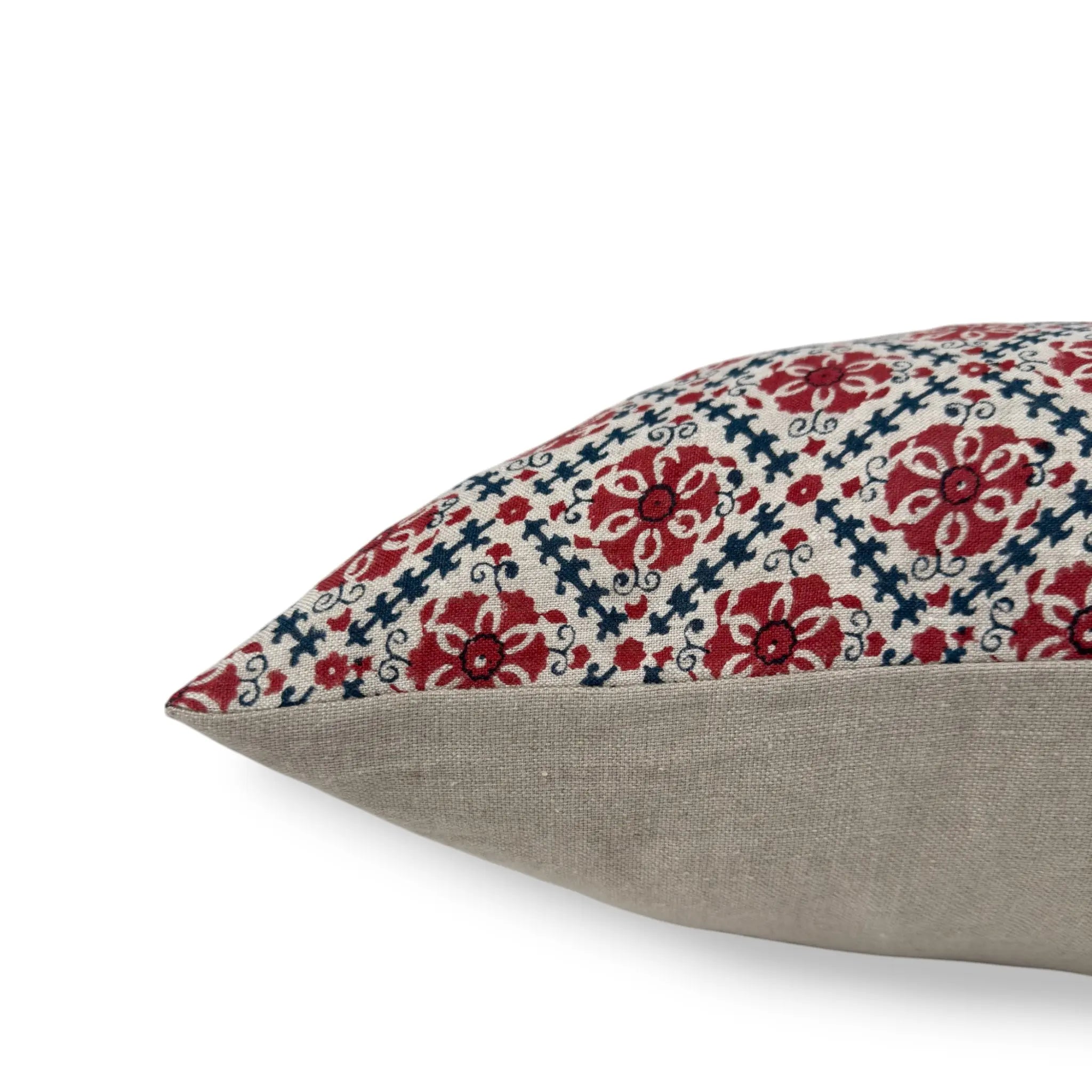 Side view of a block printed red and blue floral cushion cover