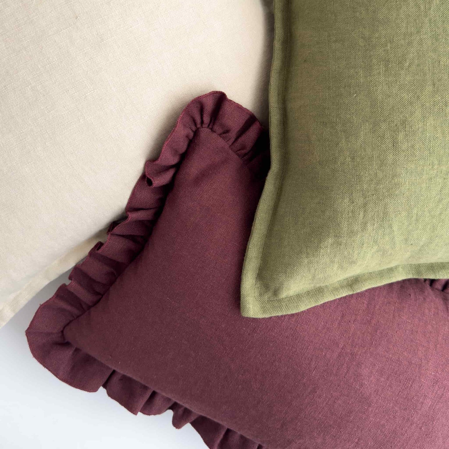 Olive green, mulberry purple and cream cushions layered together