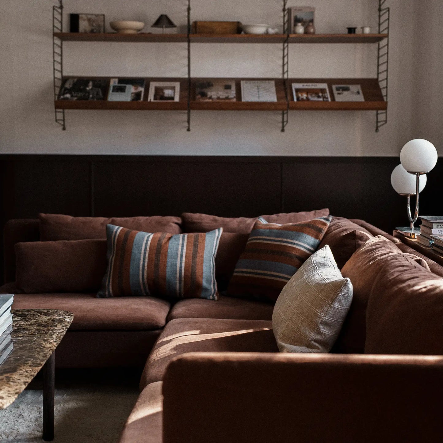 Earthy natural blue and brown cushions on brown sofa