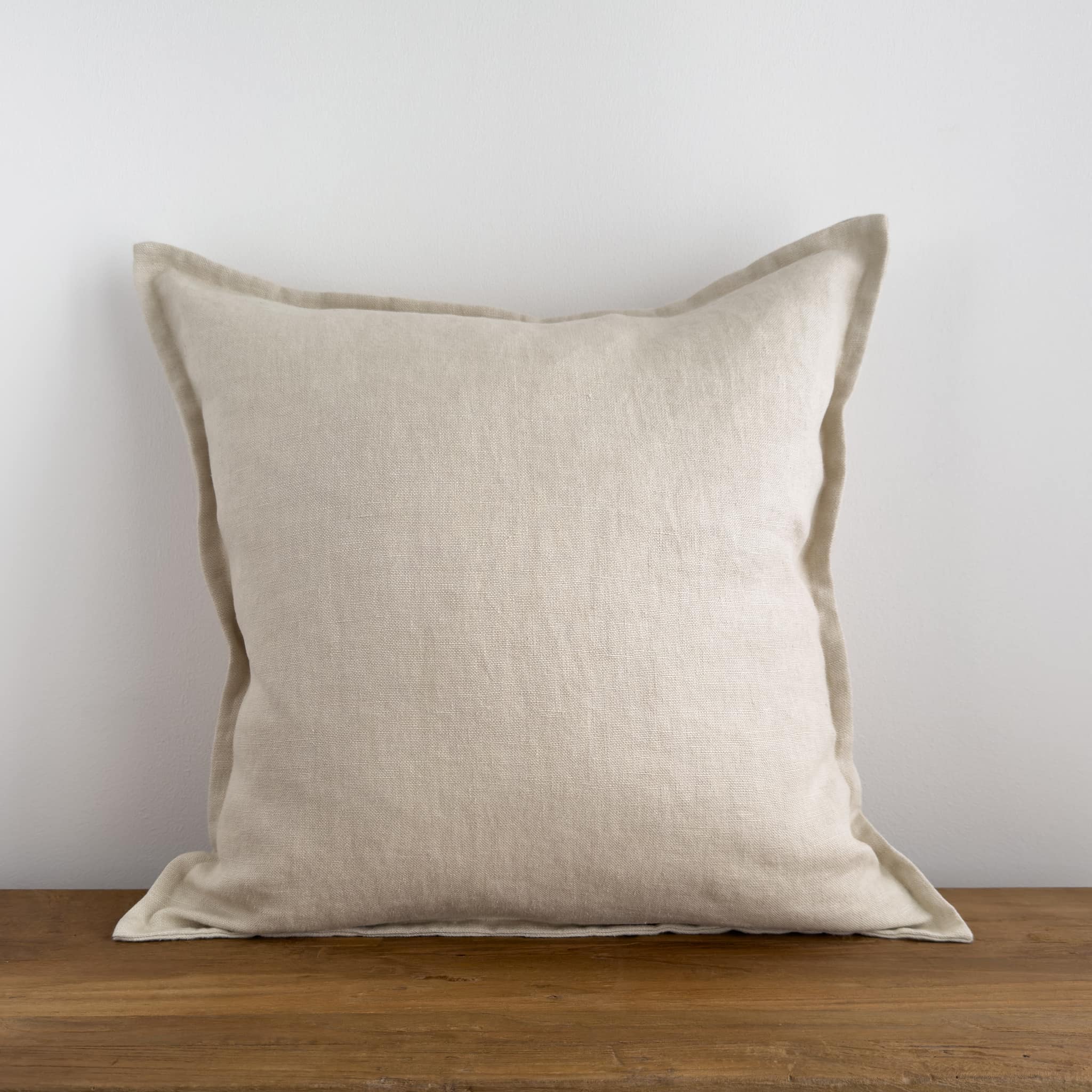 Cream linen cushion on a rustic wood bench
