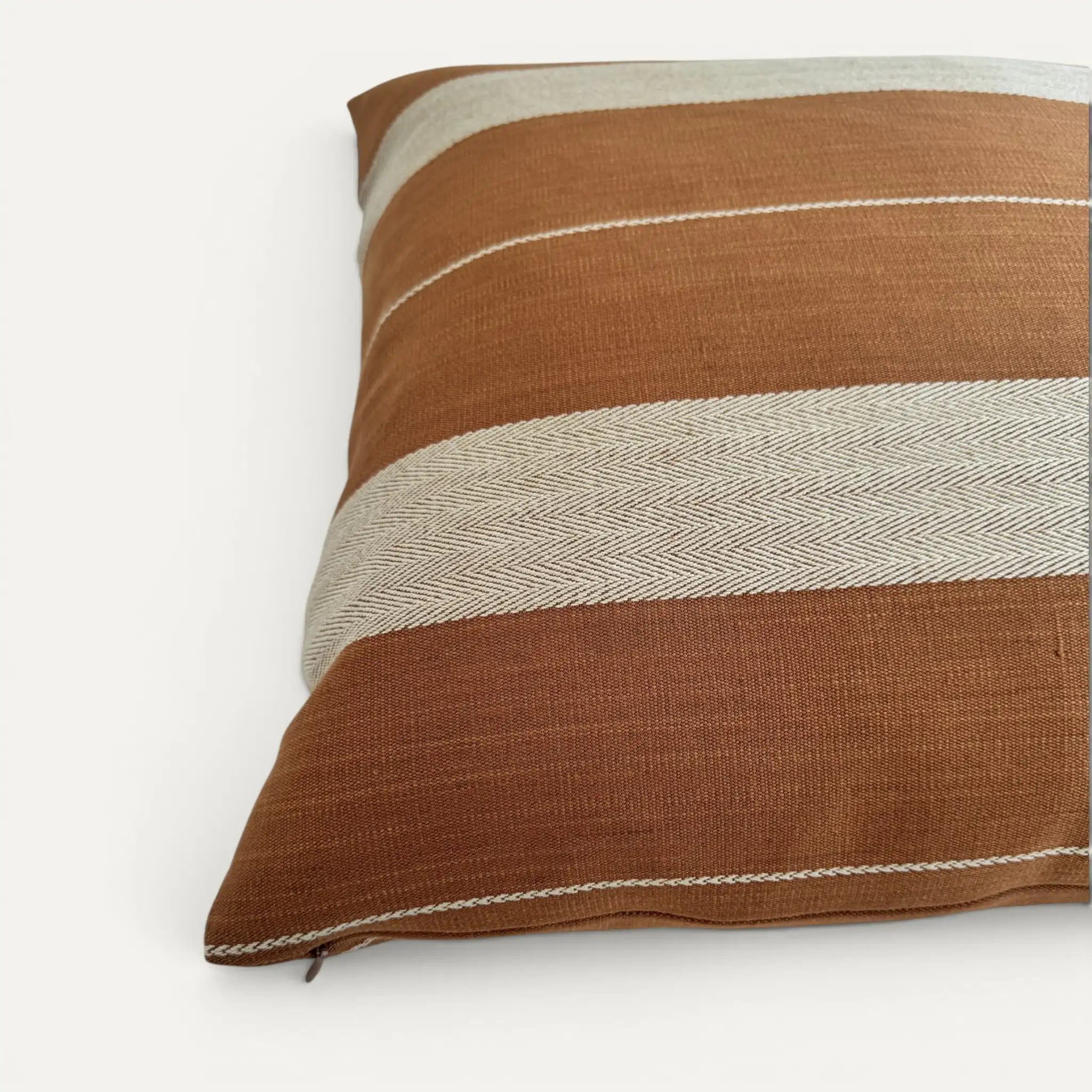 Corner detail of brown stripe cushion cover showing hidden zipper in Pamir Stripe cotton fabric by GP & J Baker
