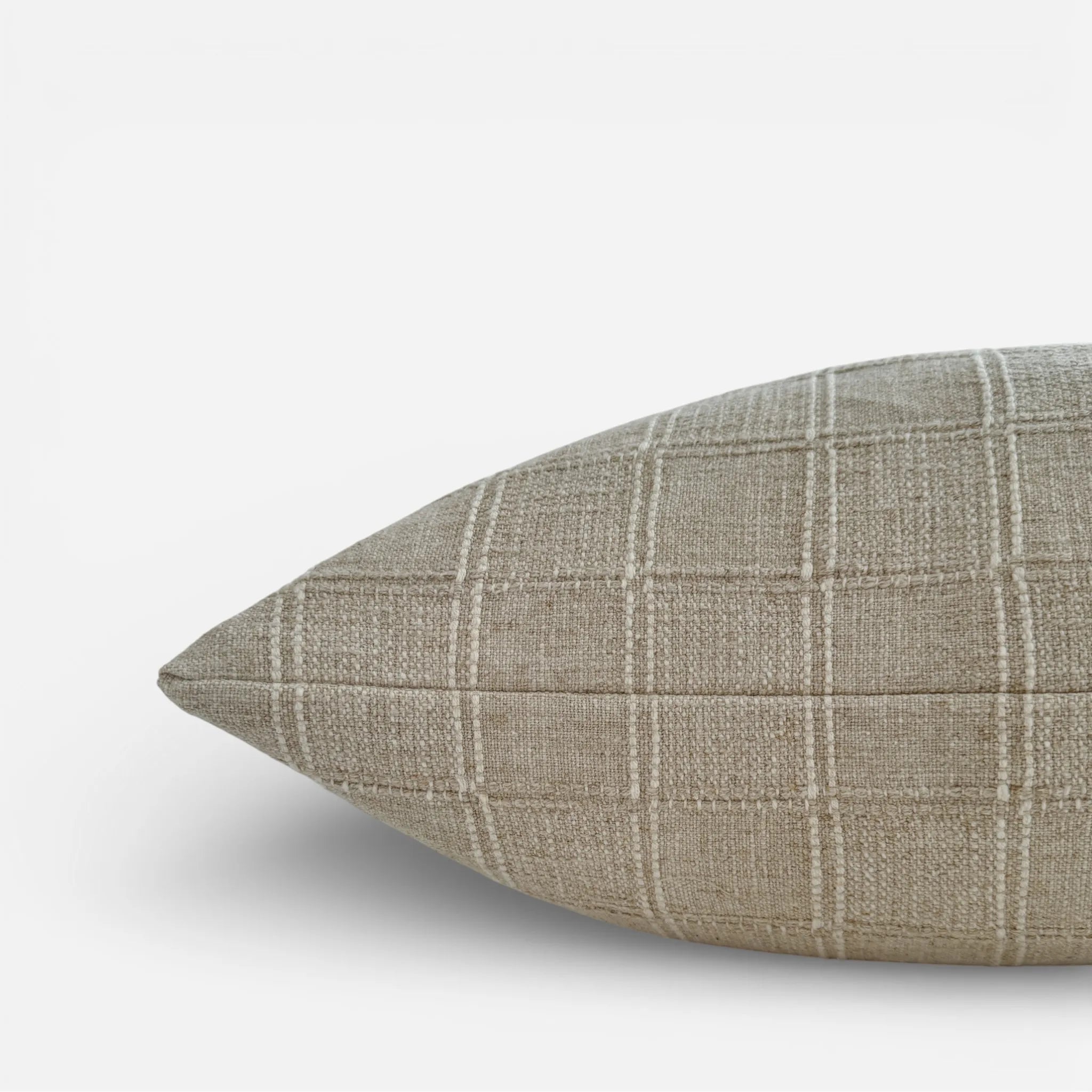 Detail view of cream coloured textured cushion cover showing the side of the cushion