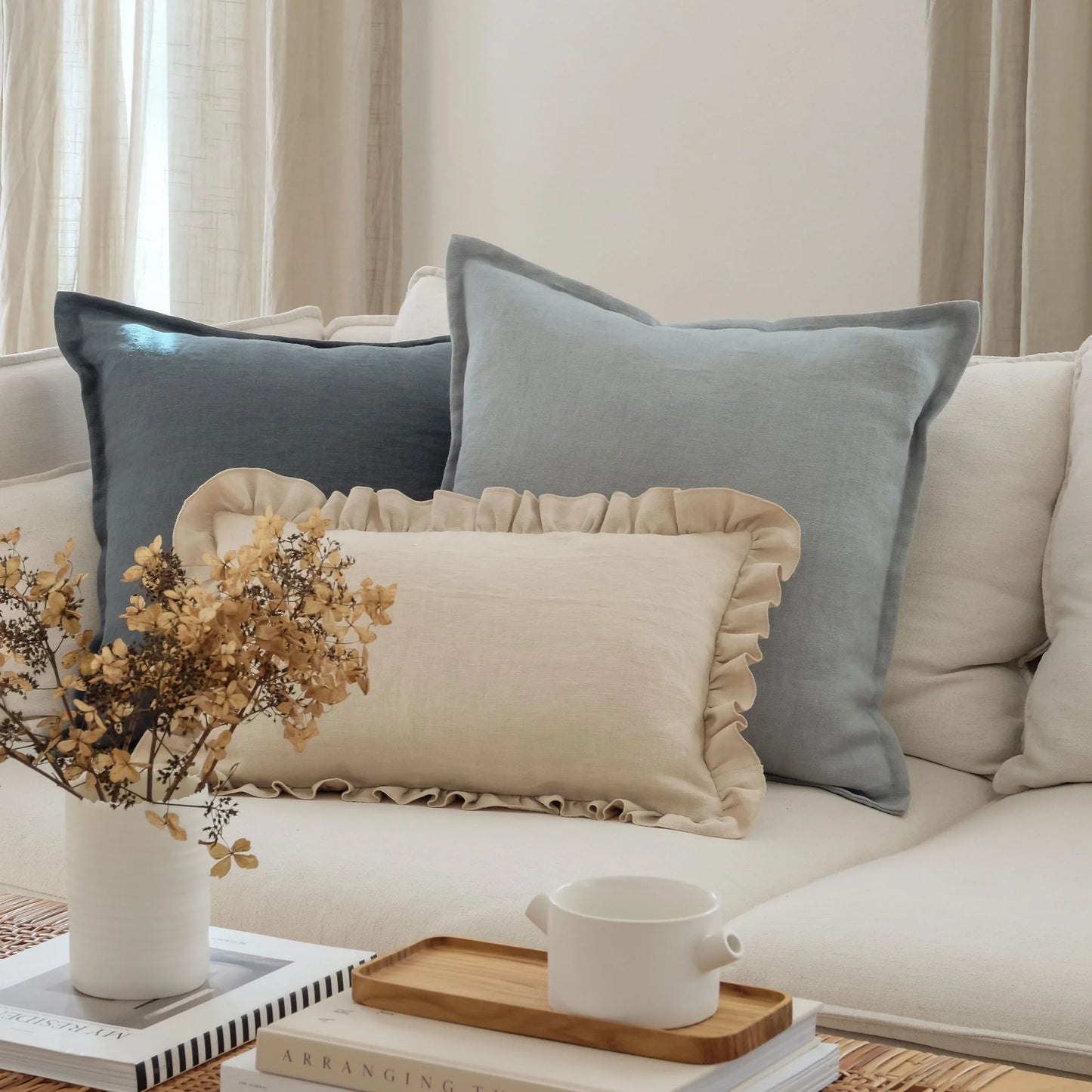 Blue and white linen cushions layered on white sofa