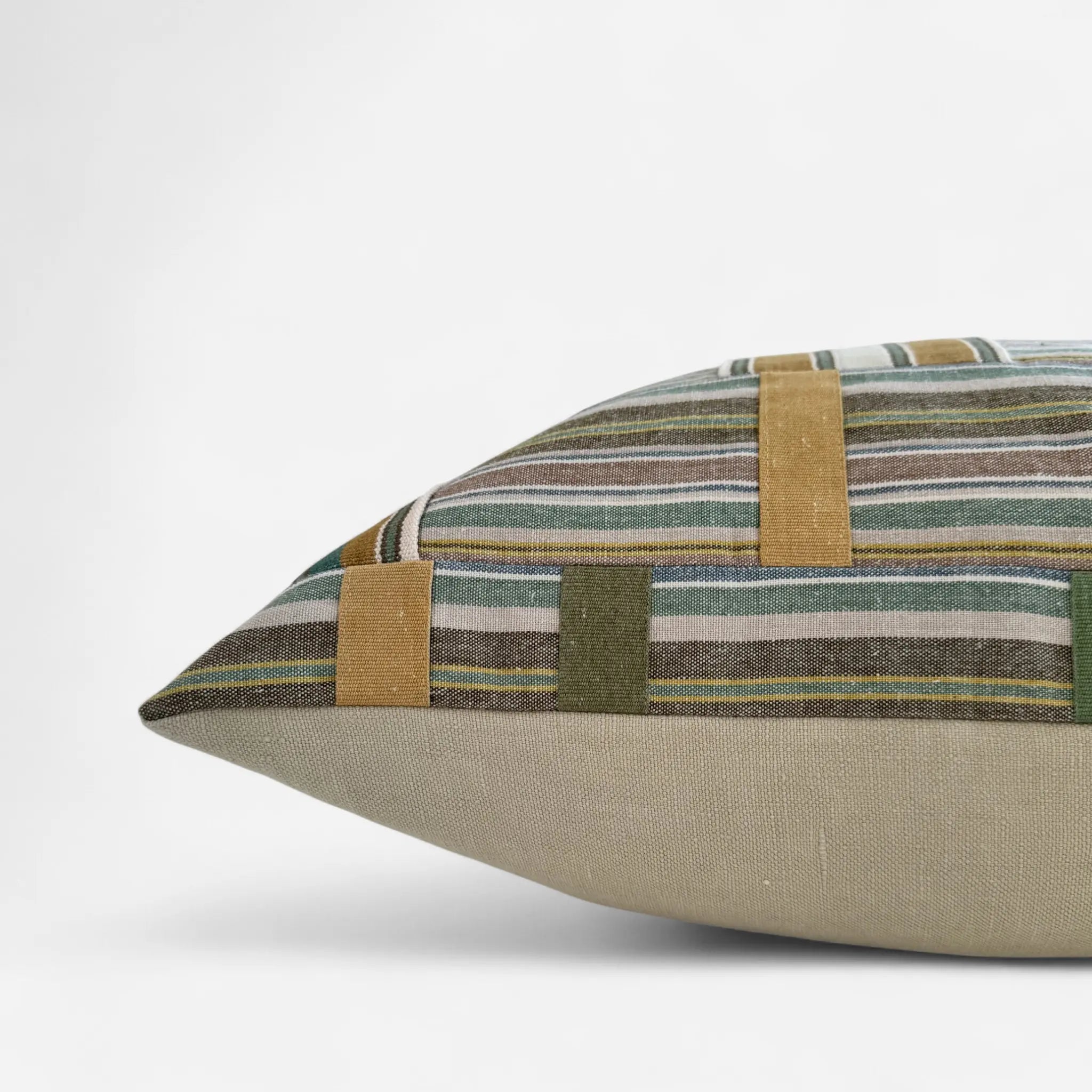 Side view of colourful patchwork cushion cover inspired by Ewe Kente Cloth textiles