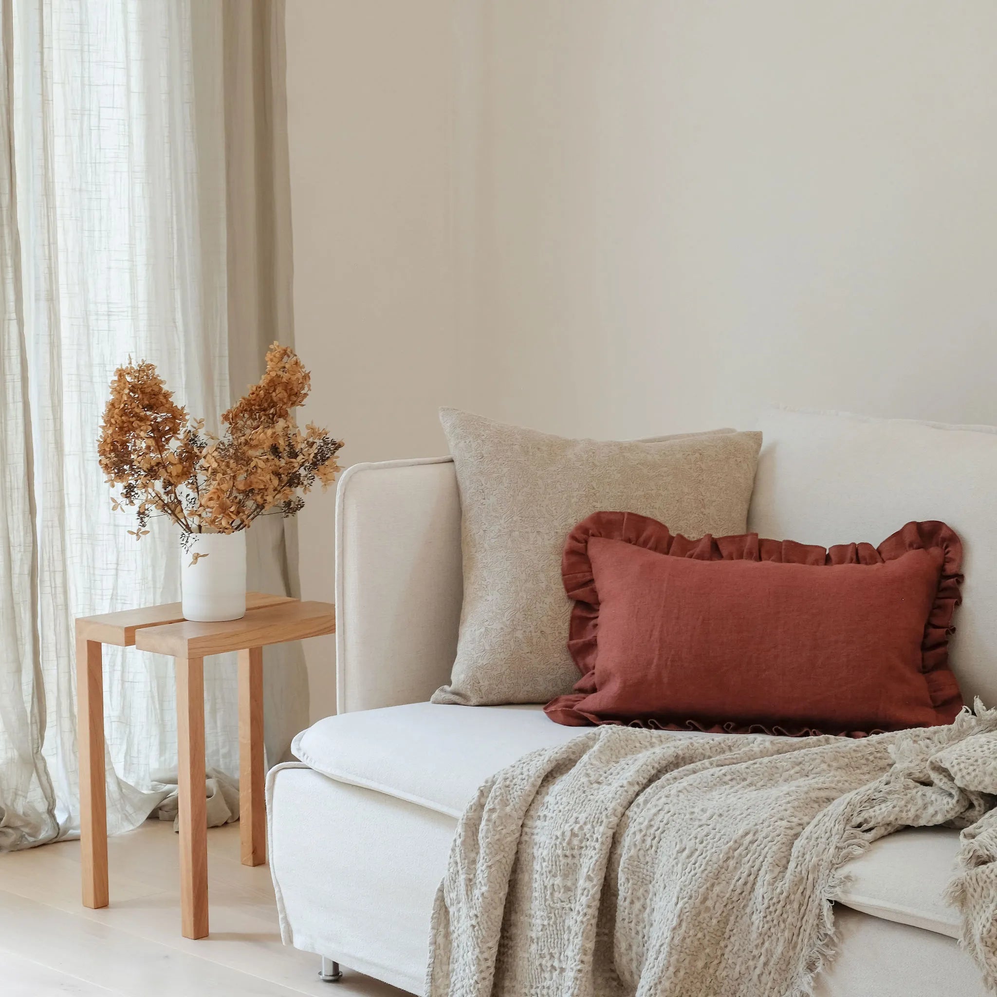 Burgundy red frill cushion styled on a sofa