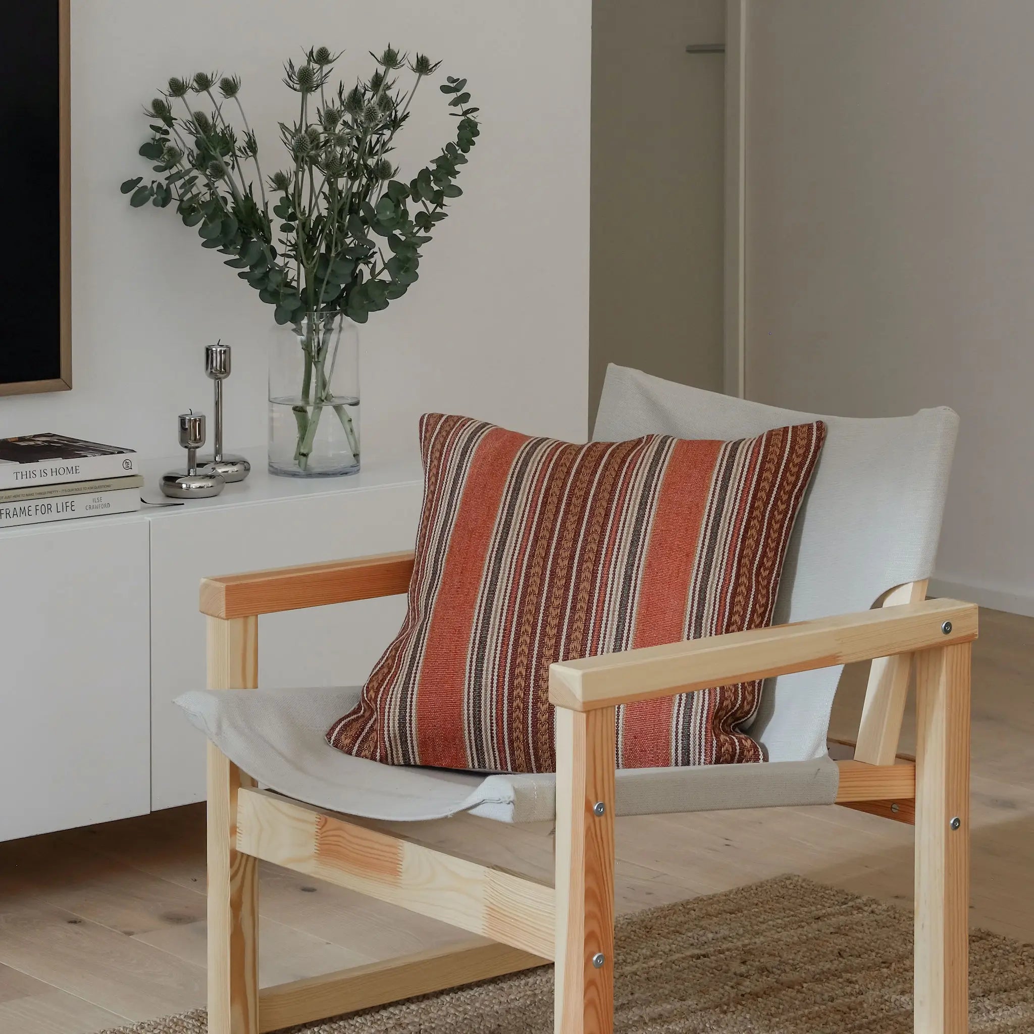 Rust red bohemian striped cushion styled in neutral interior