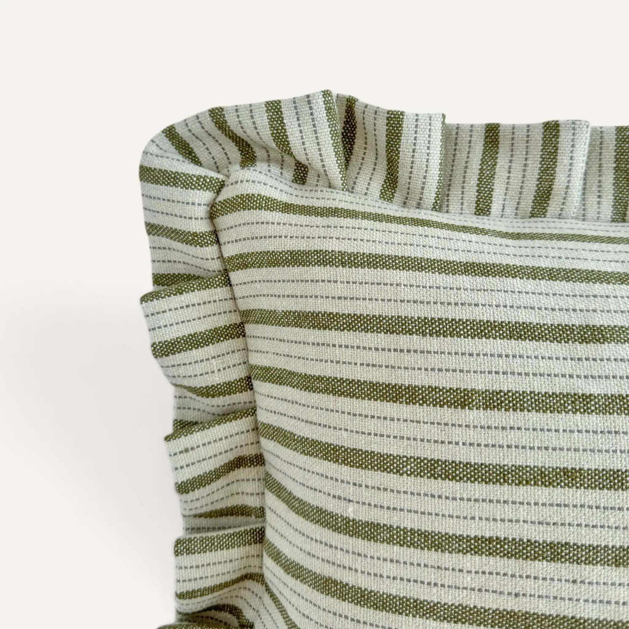 Close-up of a striped cushion with ruffled edges, featuring alternating olive green and off-white horizontal stripes on a plain light background.