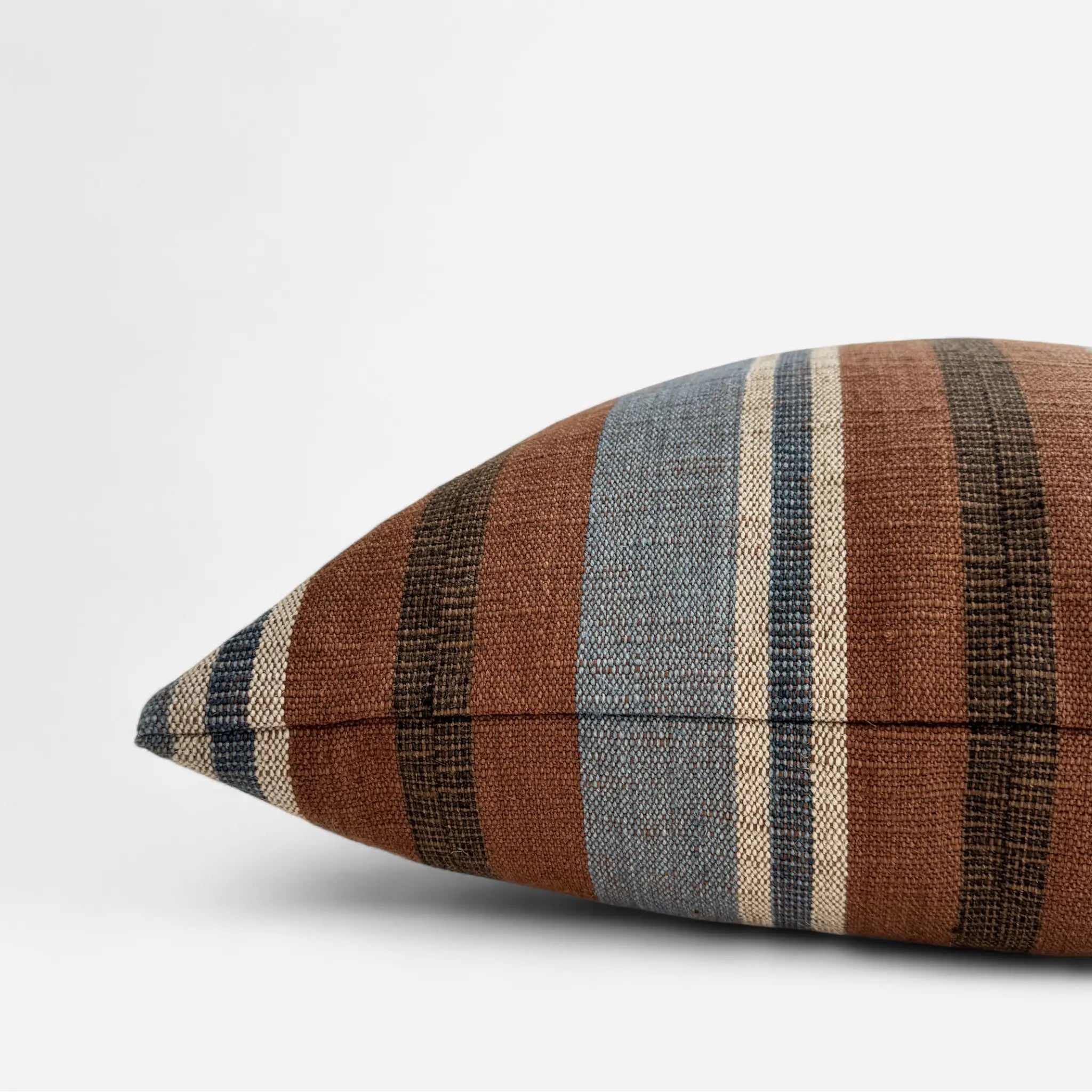 Side view of handwoven cotton and jute cushion cover in brown and blue