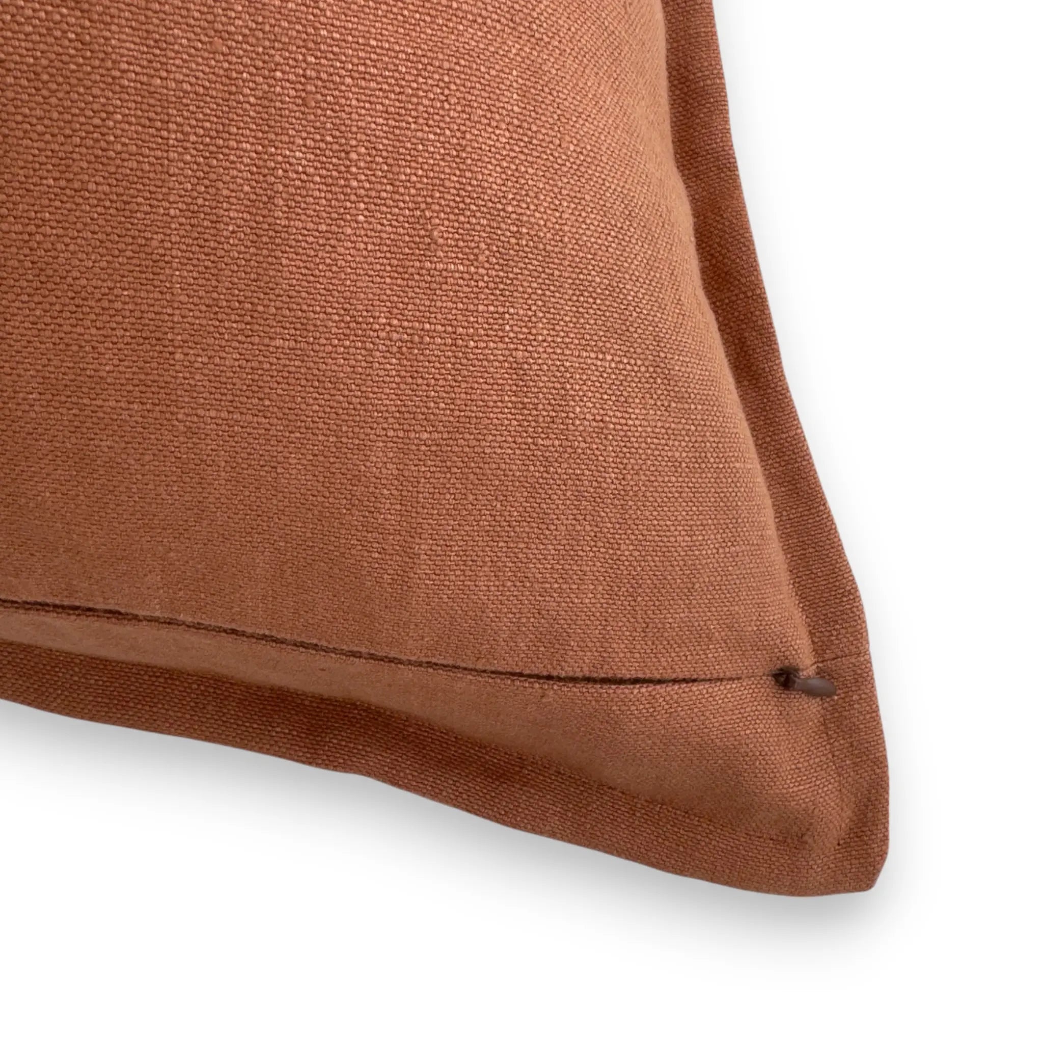 Detail view of terracotta orange linen cushion cover with concealed zipper