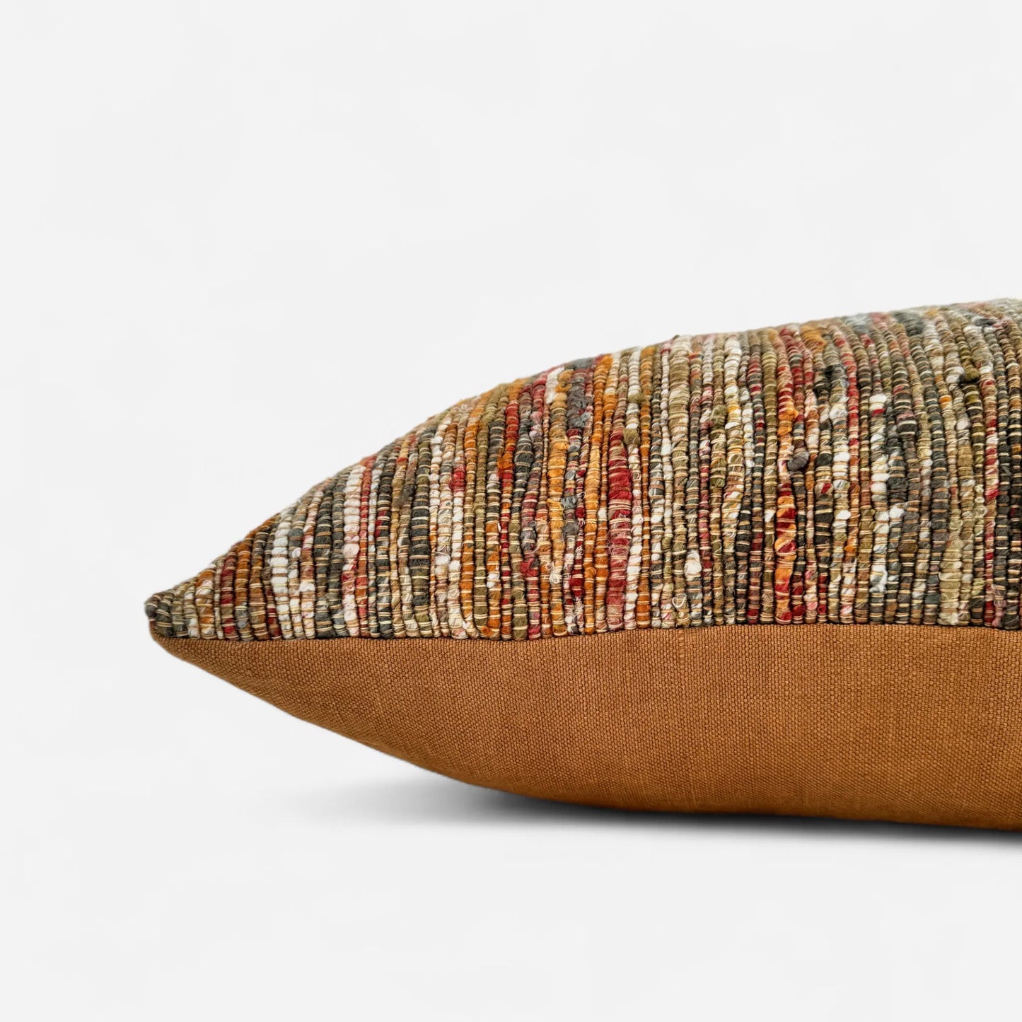 Side view of a a textured orange and green cushion cover