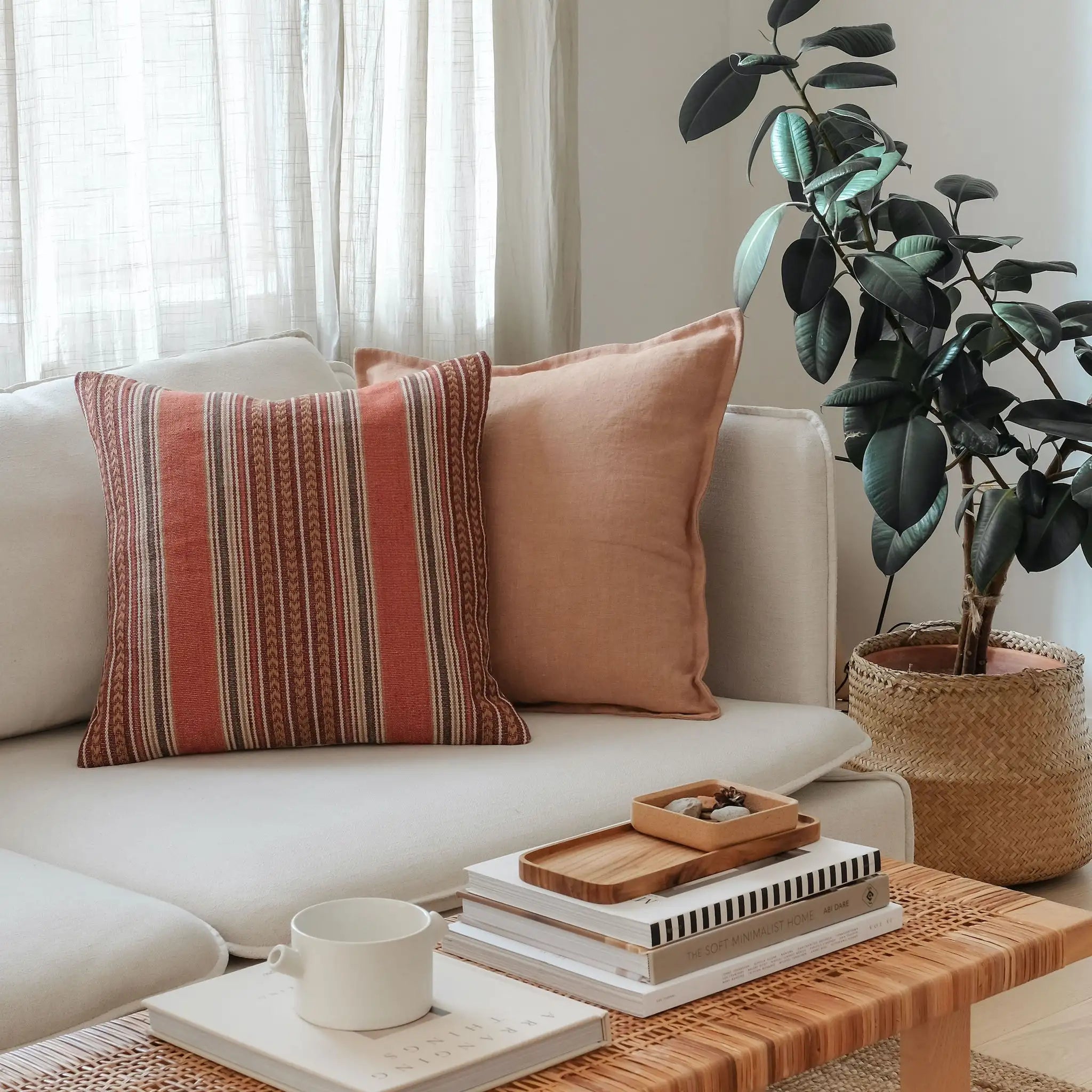 Clay brown and rust-toned cushions styled on a white sofa