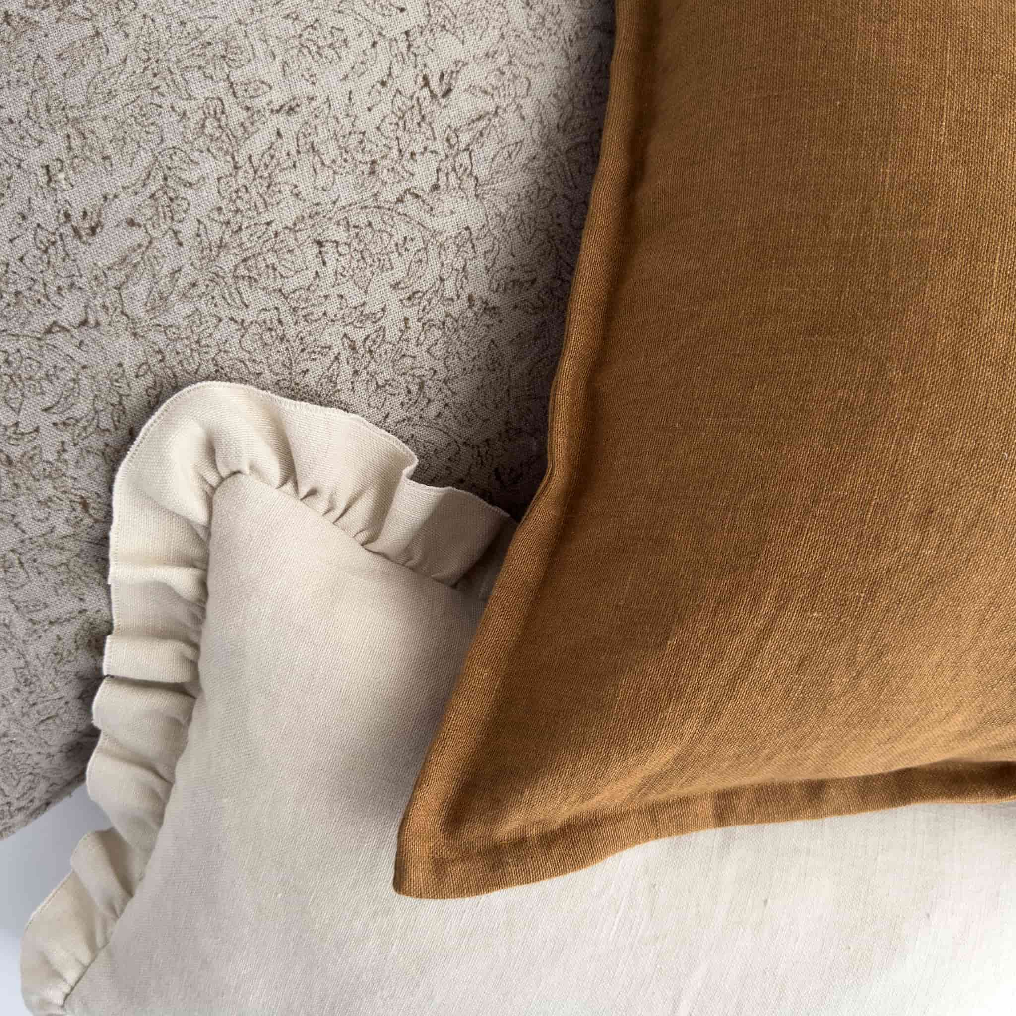 Neutral brown and cream linen cushions layered together