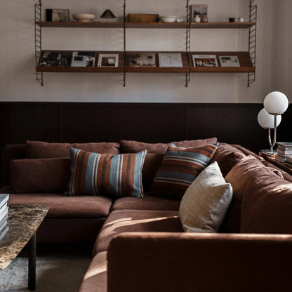 Earthy natural blue and brown cushions on brown sofa