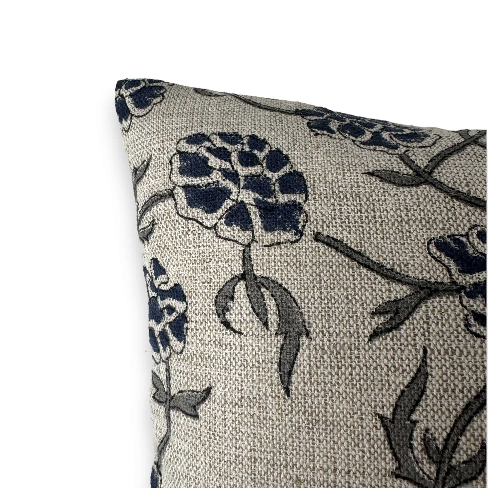 corner of beige cushion cover with blue flowers