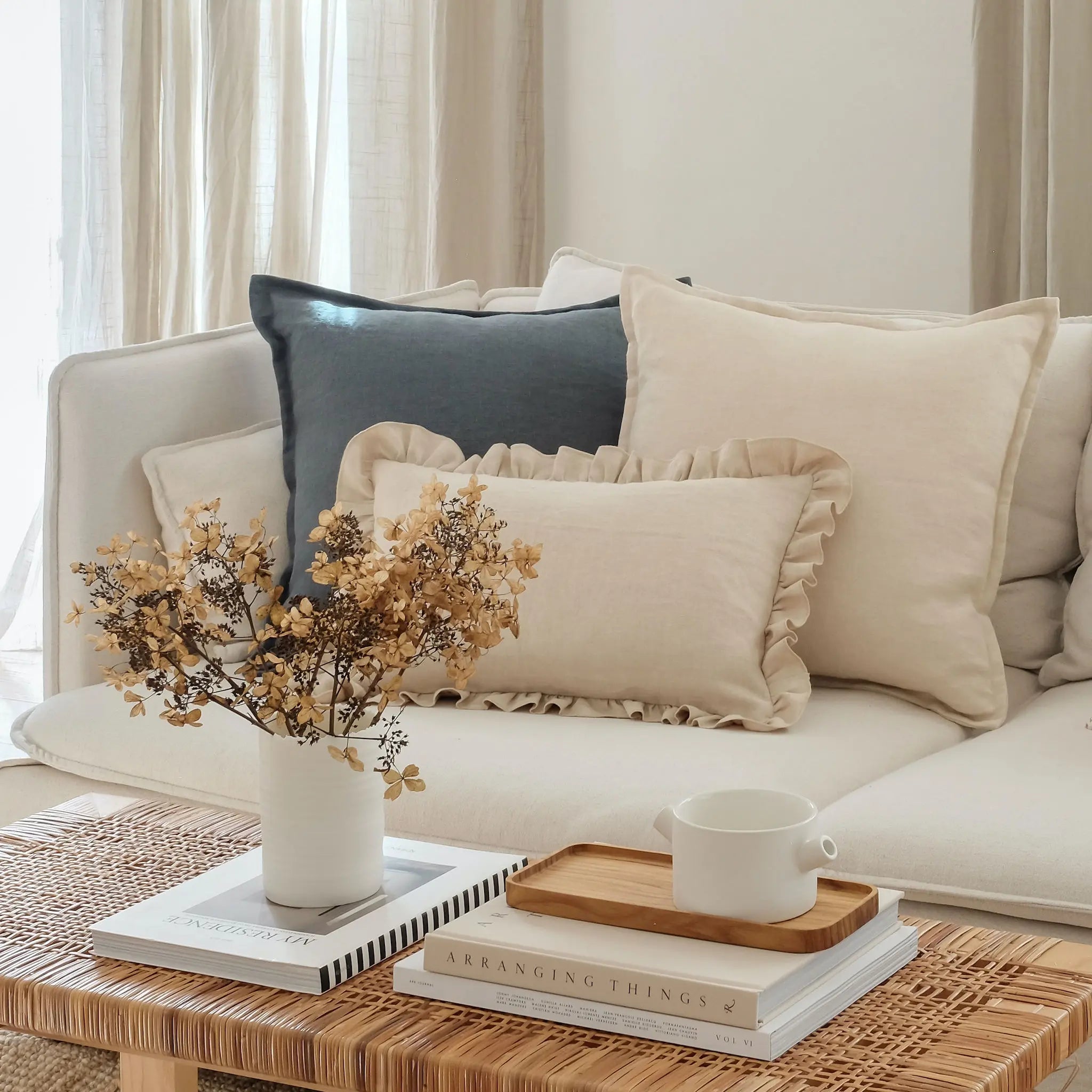 Blue and cream linen cushions styled on a white sofa