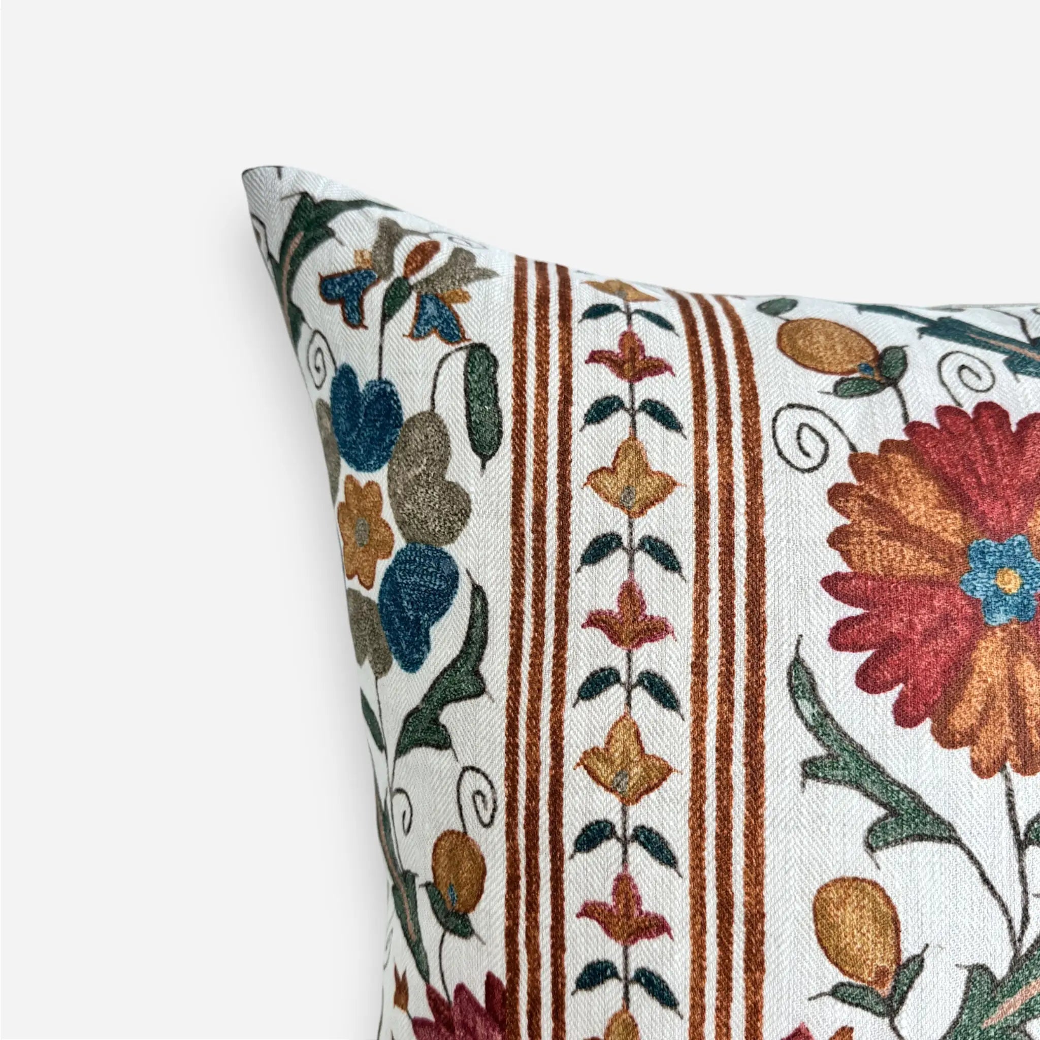Close-up of floral Suzani linen cushion cover with red floral motifs and decorative stripe