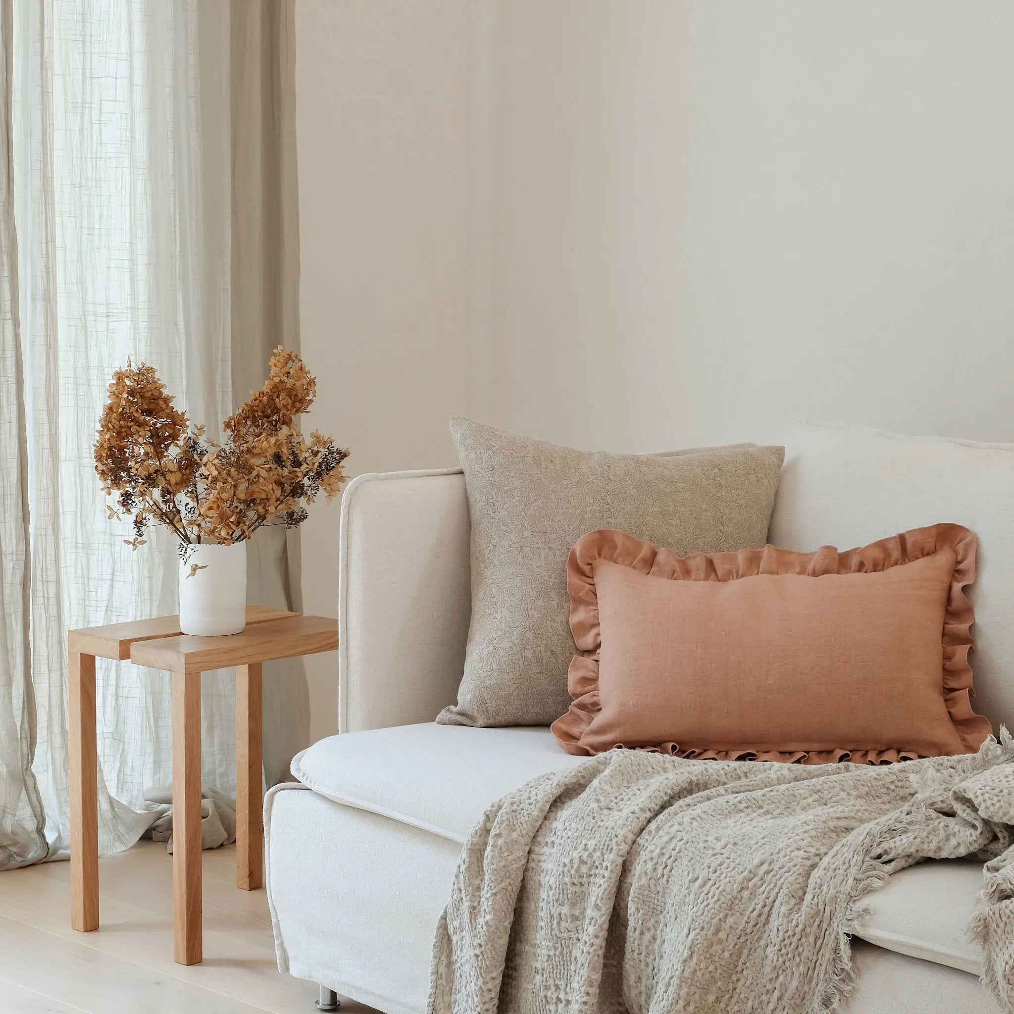 Neutral and linen frill cushion styled on white sofa