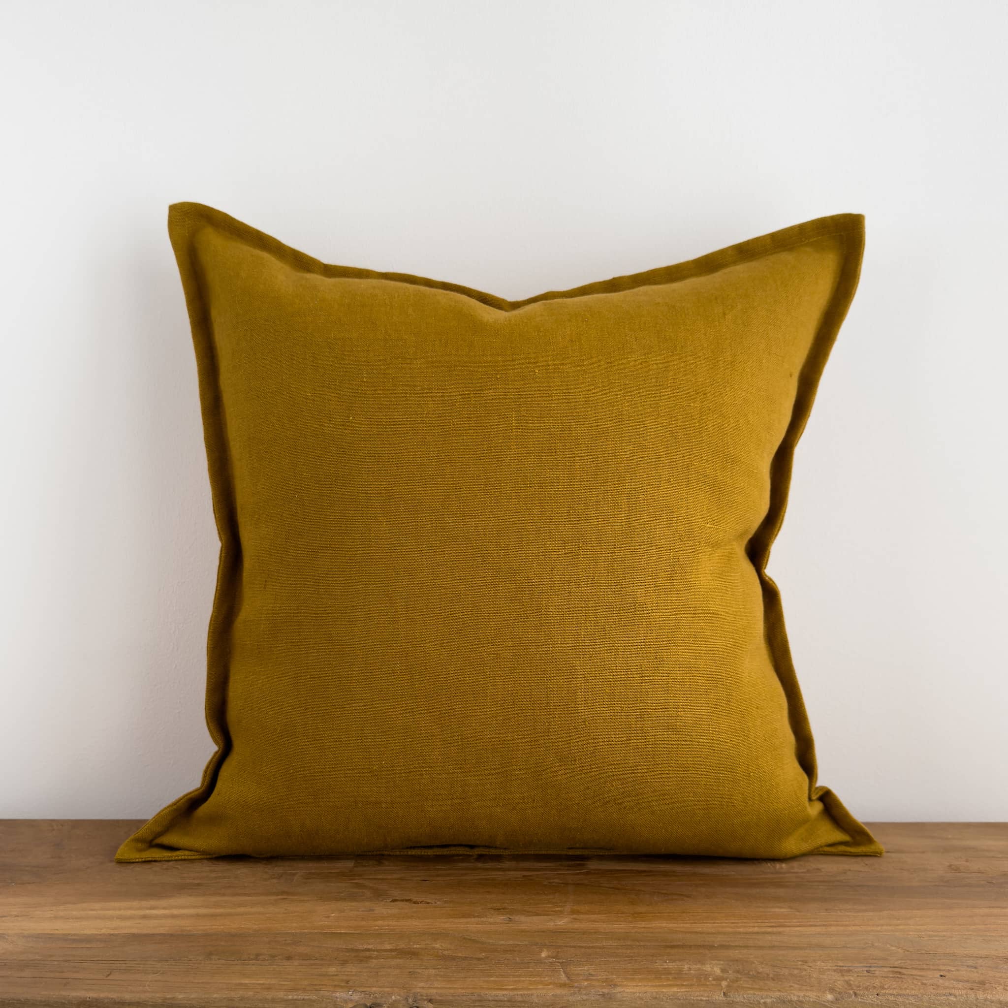 Mustard cushion on a rustic wood bench
