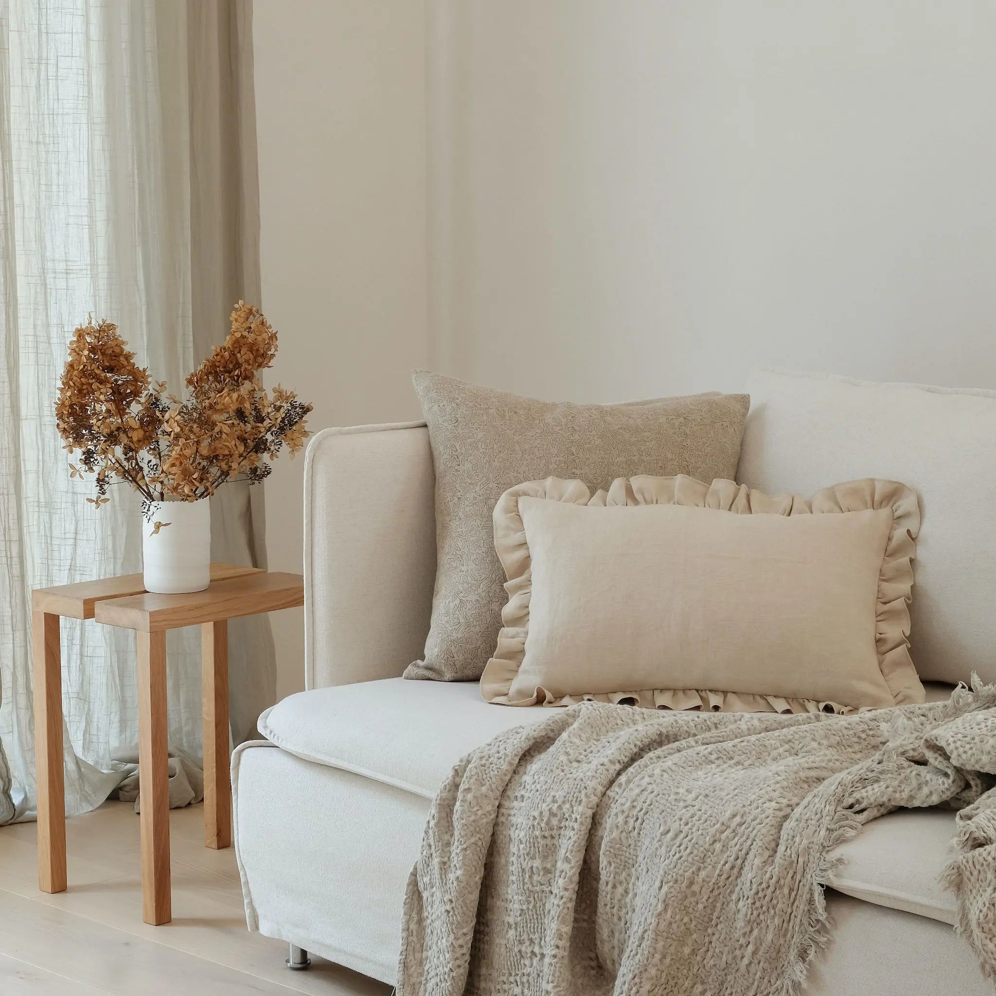 Cream frill cushion styled on sofa