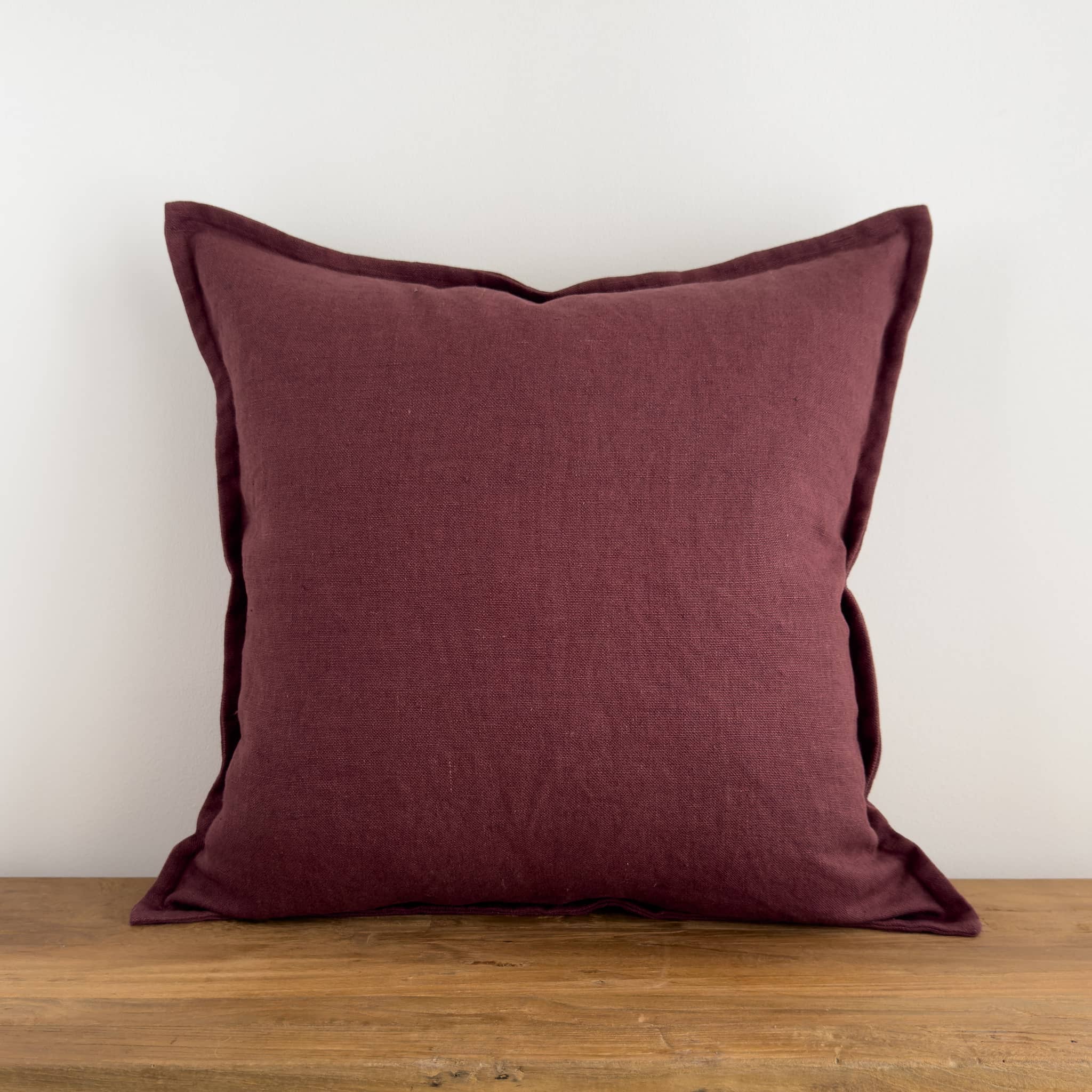 Purple linen cushion cover on a rustic wood bench