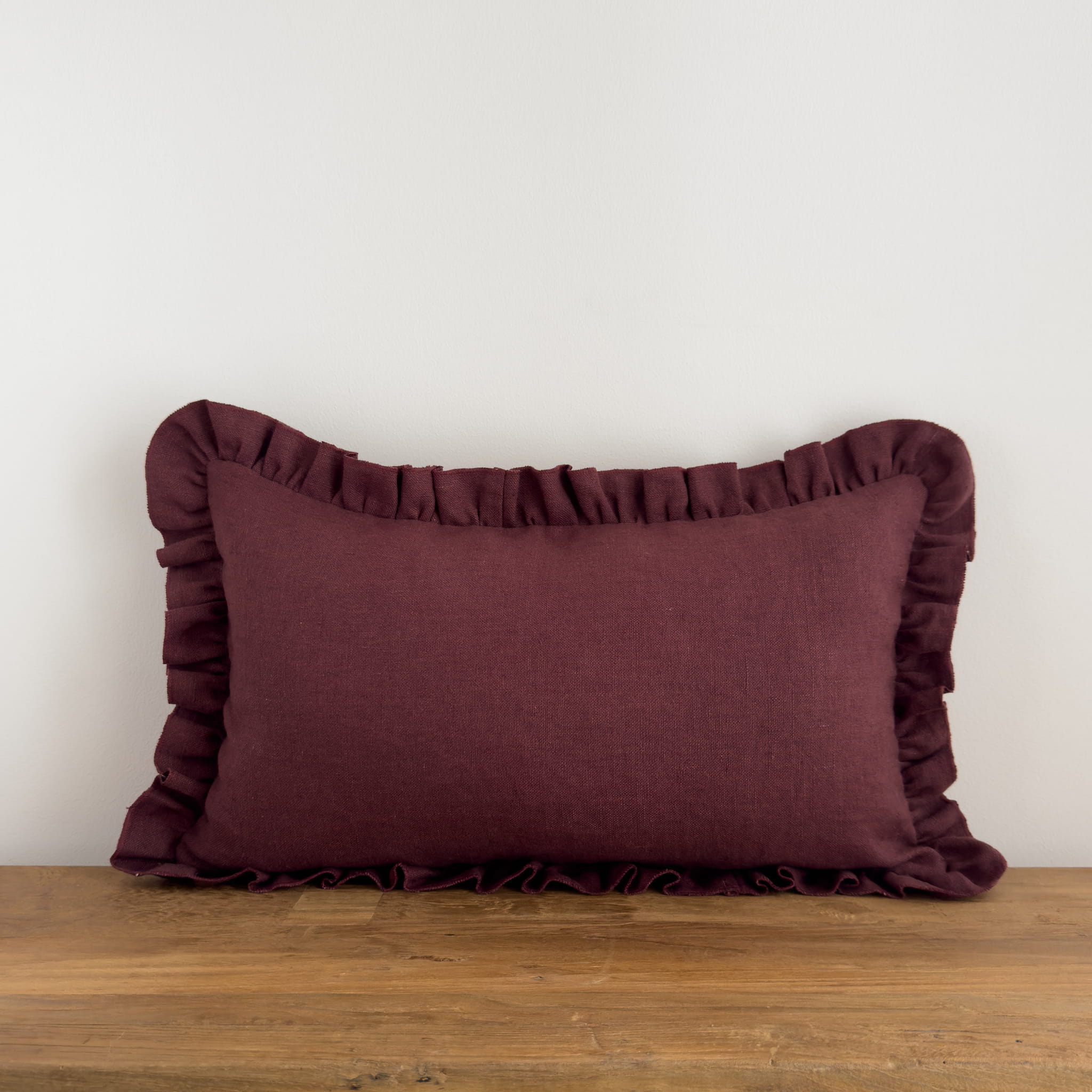 Purple frill cushion on a rustic wood bench