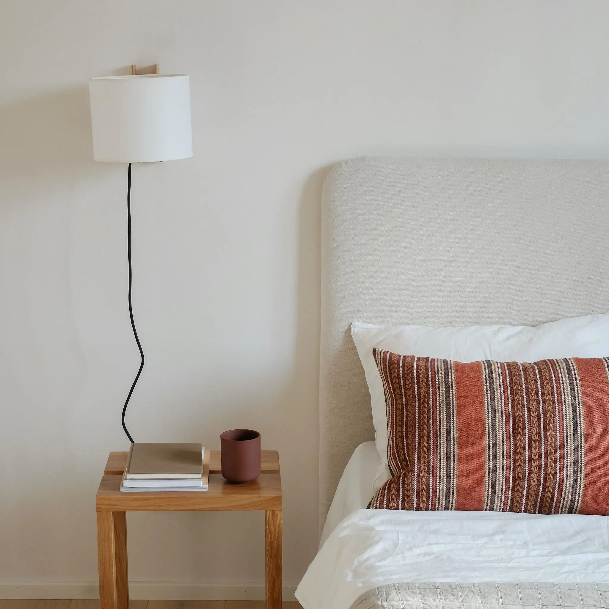 Natural warm rust red cushion styled on contemporary bedroom