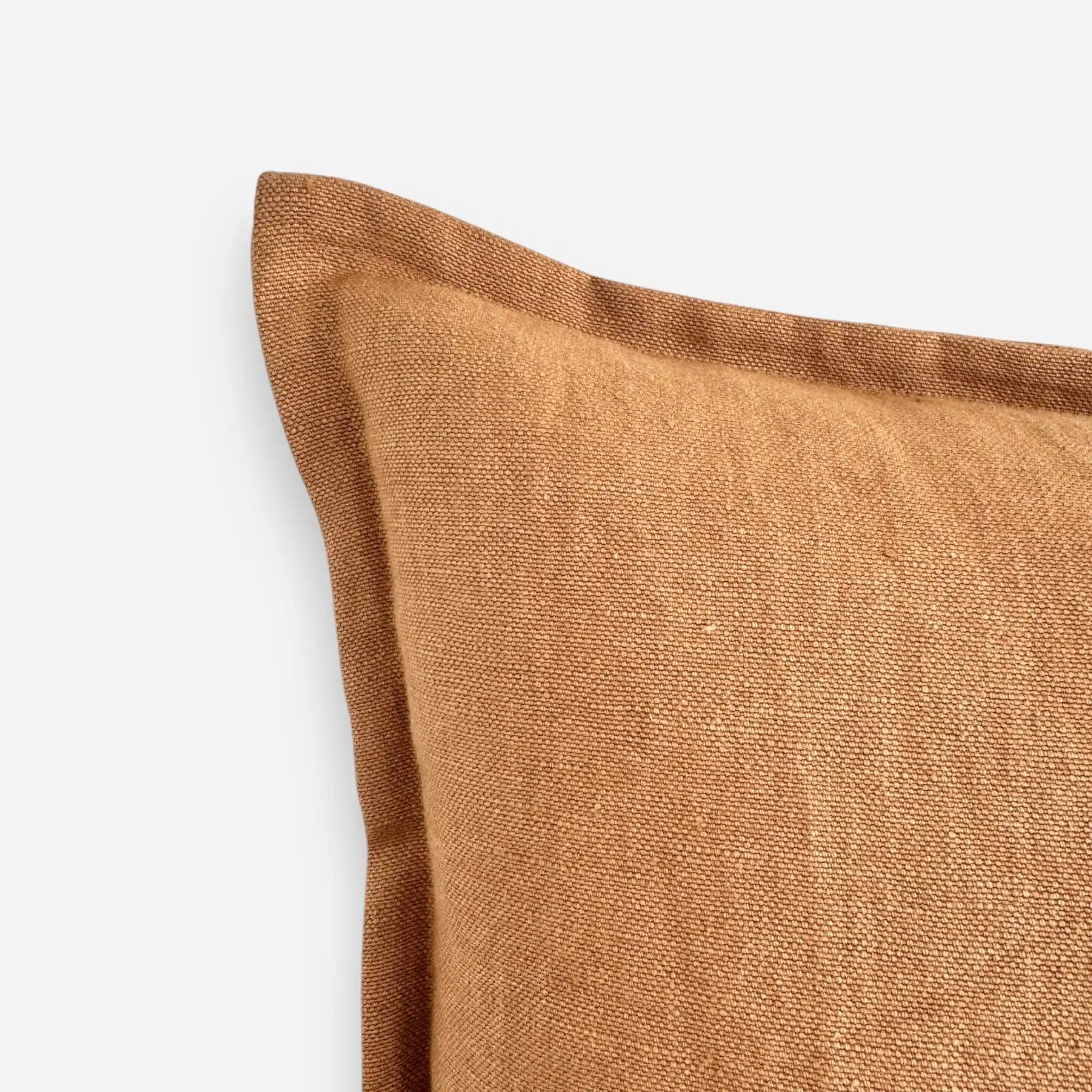 Detail view of stonewashed linen cushion cover in caramel hue